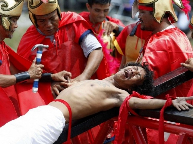 Гвозди пронзают руки распятого мужчины в страстную пятницу на Филиппинах (AP Photo/Bullit Marquez)