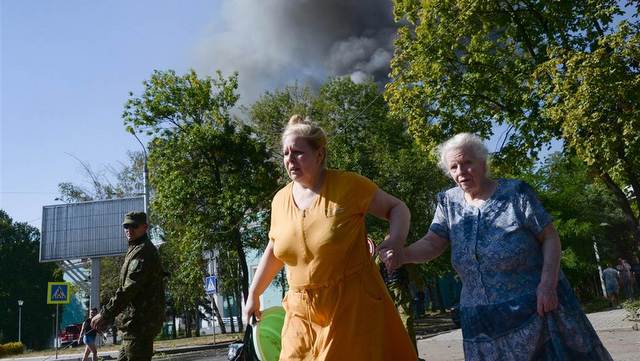 Women run from shelling in Donetsk, Ukraine. (AP Photo/Mstislav Chernov)